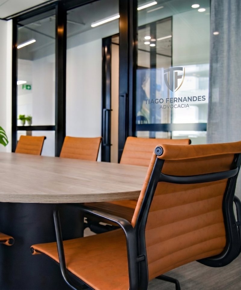 Sala de reuniões do escritório Tiago Fernandes Advocacia com logo em destaque